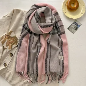 Close-up of pink and grey plaid wool blend scarf with fringe tassels and woven brand label