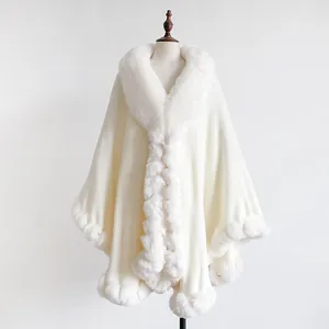 Detailed view of the plush faux fur trim on the elegant oversized beige winter cape