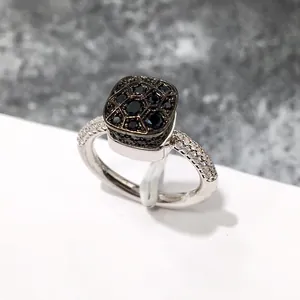 Vista detallada del anillo cuadrado con pavé de gemas negras y circones blancos laterales