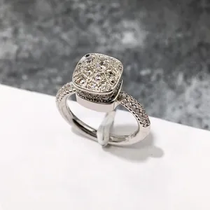 Vista macro de anillo de plata con cúmulo cuadrado de circonitas y piedras laterales