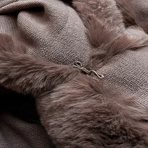 Detail of luxury coffee brown knit cape with faux fur collar and premium metal hook closure