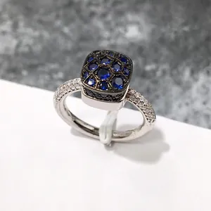 Detalle de un anillo de plata con circón zafiro azul y pavé de diamantes brillantes
