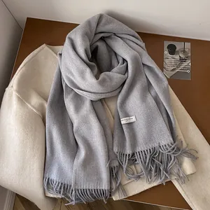 Detail of 100% wool scarf with soft fringe texture and white composition label