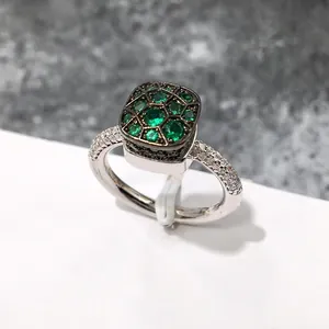 Detalle de un anillo de plata con piedras verde esmeralda y circonitas en pavé