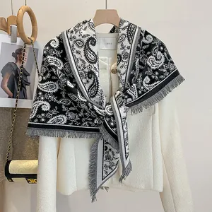 Detailed macro view of black and white paisley patterns with fine fringe on a scarf