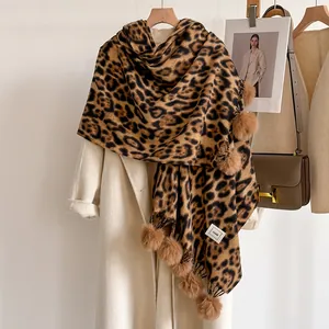 Détail de l'écharpe d'hiver léopard avec des pompons en peluche et des franges