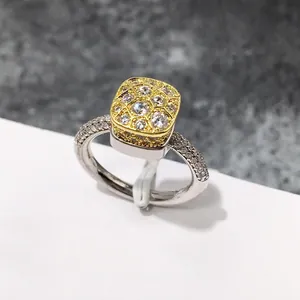 Primer plano de un anillo bicolor con diseño de panal y pavé de circonitas brillantes