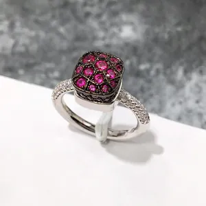 Primer plano de anillo de plata con piedra fucsia y detalles de pavé de circonitas