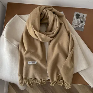 Detail of camel wool scarf showing 100% pure wool texture and elegant tassel edges