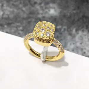 Vista macro de anillo dorado con pavé de circonitas cuadradas y diamantes laterales