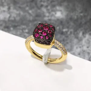 Macro de anillo dorado con piedras rojas y grabado Au750 de detalle