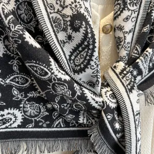 Classic paisley print triangle scarf with tassels styled on a cream tweed jacket