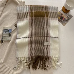 Close-up of wool blend plaid scarf with classic tassels and branded fabric label