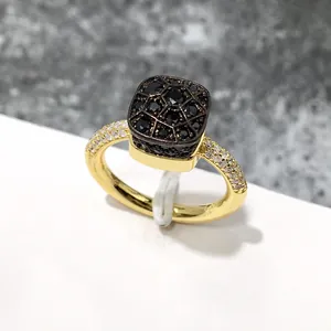 Vista macro detallada de un anillo de oro con piedras pavé negras sobre mármol