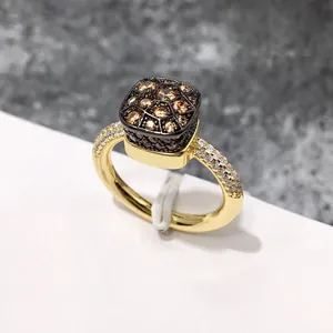 Detalle macro de anillo de panal con pavé de circón champán en engaste negro
