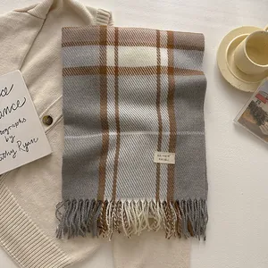 Detailed close-up of wool blend plaid scarf with thick fringe and elegant brand label