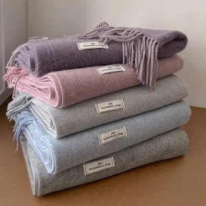 Solid color wool scarves with long tassels and vintage woven labels in five soft colors