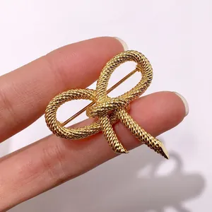 Detailed macro of golden twisted rope knot brooch with elegant metallic texture details