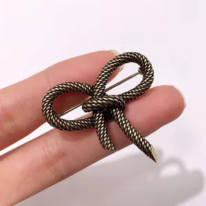 Close-up of vintage bow brooch featuring a twisted rope texture and antique gold finish