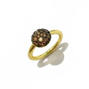 Vue macro d'une bague vintage plaquée or avec zircons micro-sertis marron et noir