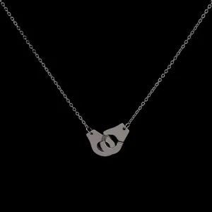 Silver handcuffs pendant necklace with fine link chain on a professional black background