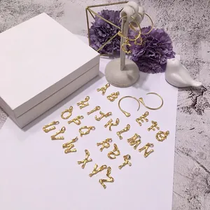 Orecchini a cerchio dorati con ciondoli a forma di lettere con trama spazzolata cool
