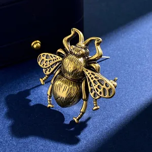 Vintage gold honey bee brooch with hollow carved wings on elegant navy blue velvet background