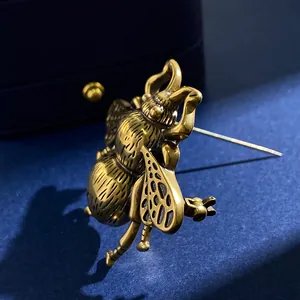 Macro detail of a vintage bronze bee brooch with intricate hollowed wings and texture