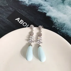 Dettaglio macro di orecchini pendenti argento con pietre marquise e gocce blu