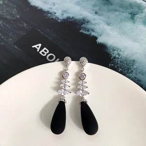 Dettaglio di orecchini pendenti in argento con pietre marquise e perle nere eleganti