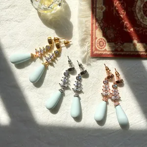 Dettaglio orecchini pendenti con cristalli marquise e perle blu smerigliate