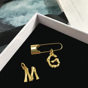 Golden bamboo texture brooch with alphabet G pendant on luxury black velvet background