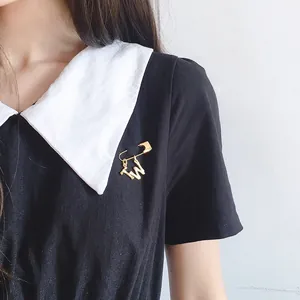 Fashion gold letter brooch with T and W charms on black dress with white collar