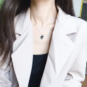 Golden S925 silver necklace with a blue enamel zodiac pendant worn by a model
