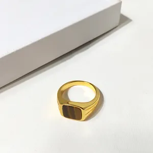 Détail d'une bague dorée vintage avec une pierre œil-de-tigre rectangulaire