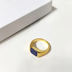 Vue détaillée d'une bague chevalière dorée avec une pierre bleu marine polie