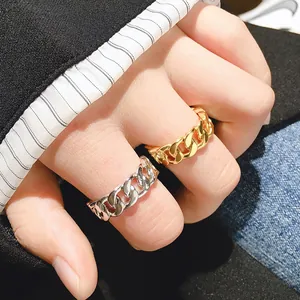Macro shot of gold and silver chain link rings styled with a formal suit and casual denim