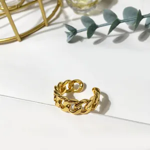Close-up of golden twist chain ring with eucalyptus leaves on a white background