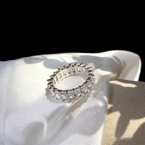 Macro shot of silver eternity ring with emerald cut cubic zirconia on silk background