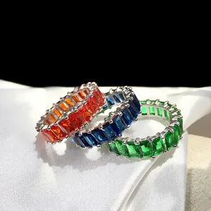 Three emerald cut rainbow cubic zirconia eternity rings on white silk fabric