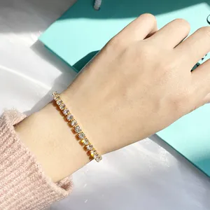 Sparkling 4mm zircon tennis bracelet with gold finish worn on a wrist in natural sunlight