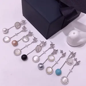 Asymmetric star and shell pearl drop earrings featuring marquise cubic zirconia accents