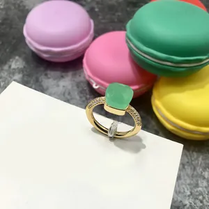Detalle de anillo dorado con gema verde esmeralda cuadrada y circonitas brillantes