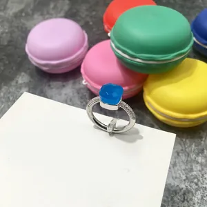 Primer plano de anillo con piedra azul cuadrada tallada y diamantes en banda plateada