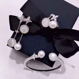 Macro shot of silver jewelry set with pearls and star-shaped crystals on a black gift box