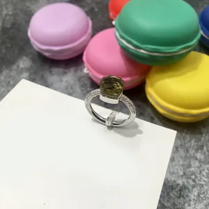 Primer plano detallado de un anillo de piedra verde esmeralda facetada con detalles de diamantes