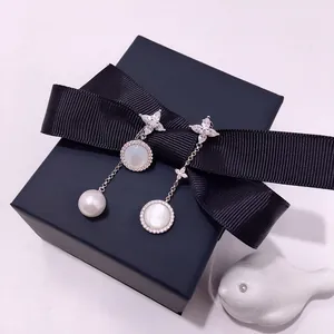 Detail of asymmetric silver earrings with marquise diamonds, mother-of-pearl and white pearl