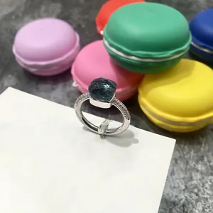 Primer plano detallado de un anillo con gema azul de corte cojín y pavé de diamantes finos