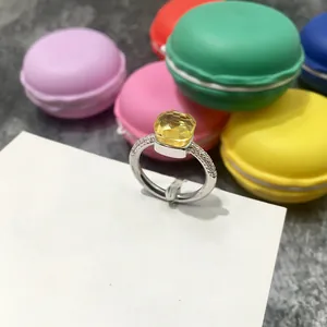 Vista detallada de un anillo con gema amarilla cuadrada y pavé de diamantes en banda de plata