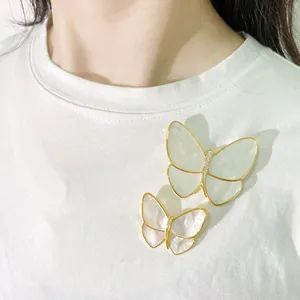 Elegant white shell butterfly brooch set with gold plating and sparkling crystals